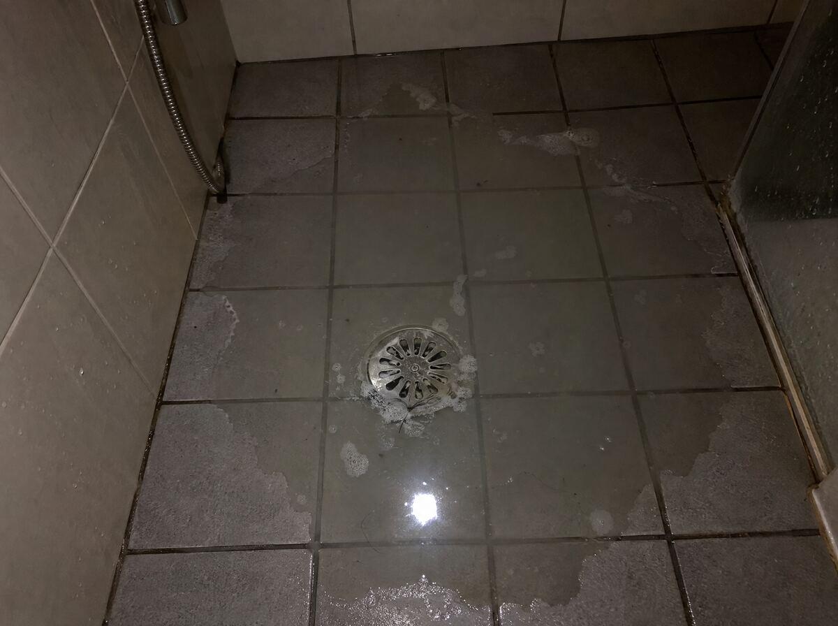 Douchevloer met staand water rond het putje